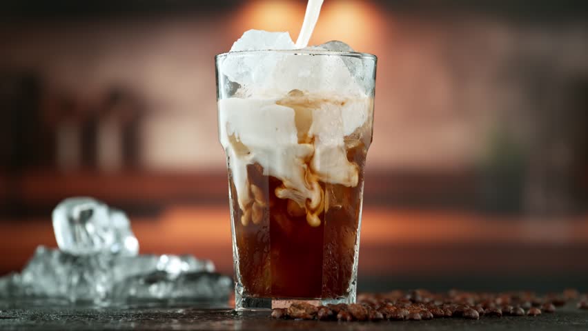 Super Slow Motion Shot of Pouring Milk into Ice Coffee , Filmed on High Speed Cinematic Camera