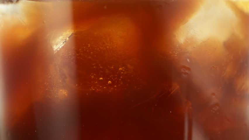 Super Slow Motion of Pouring Milk Into Ice Coffee Drink, Close-up. Filmed on High Speed Cinema Camera, 1000 fps.