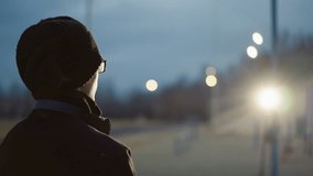 Side view of a young boy in black outfit and glasses, lifting a ball with a headset around his neck, the background features a blur of light reflection - Powered by Shutterstock - Get 15% off with code: PIKWIZARD15