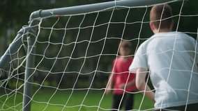 A close-up of a goal post captures the moment when a player in red shoots the ball into the net, and the goalkeeper misses the save, with the players clapping their hands in celebration, - Powered by Shutterstock - Get 15% off with code: PIKWIZARD15