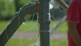 A close-up of a soccer ball hitting the goalpost net as the blurred goalkeeper tries to save the ball with his right hand after it has entered the goal post - Powered by Shutterstock - Get 15% off with code: PIKWIZARD15