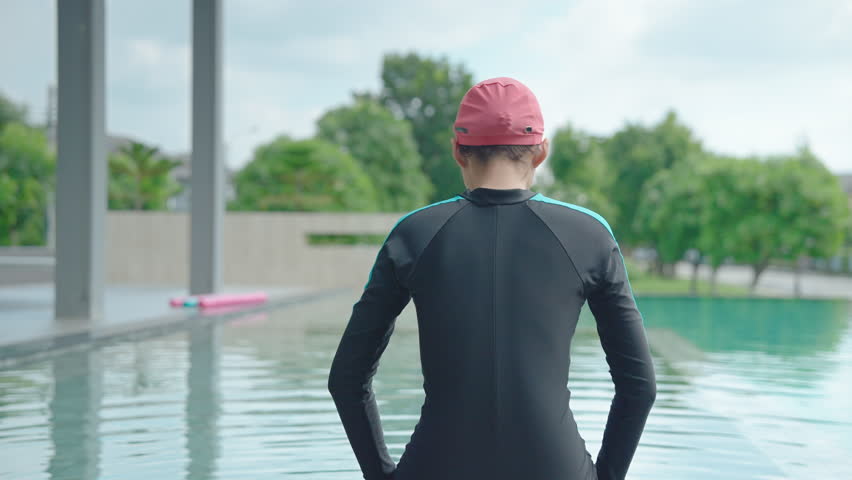 Behind the woman is sitting by the pool.