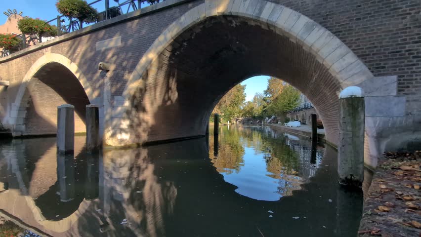 Utrecht, the Netherlands. 22 September 2024. In Front of an arch bridge, a view of the canal in Utrecht and the wharves with more arch bridges in the distance.