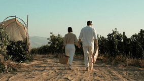 Couple in love walking through vineyards holding hands. Young woman and man dating outdoors at nature during grapes harvest season. Travel, honeymoon, winery - Powered by Shutterstock - Get 15% off with code: PIKWIZARD15
