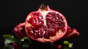 Pomegranate. Fresh juicy Pomegranates with leaves isolated on black background. Beautiful Organic Bio fruits closeup, rotating. Slow motion   - Powered by Shutterstock - Get 15% off with code: PIKWIZARD15