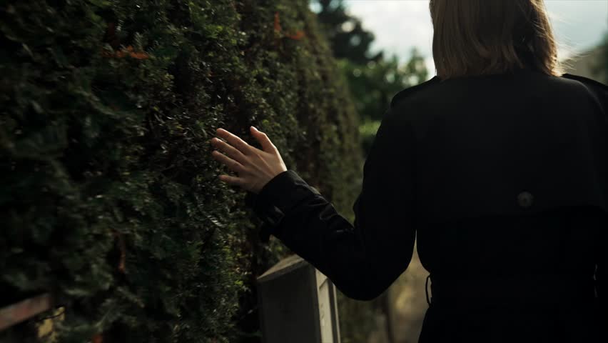 A young girl walks along a city street in slow motion. Rear view.