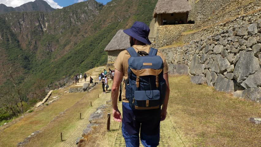 Rear view of young tourist visiting Machu Picchu in Peru. People, travel and holiday lifestyle concept.
