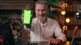 Old Caucasian man businessman looking at camera mobile phone smartphone showing green screen display technology internet social network web cyberspace connection e-commerce freelance e-business elder - Powered by Shutterstock - Get 15% off with code: PIKWIZARD15