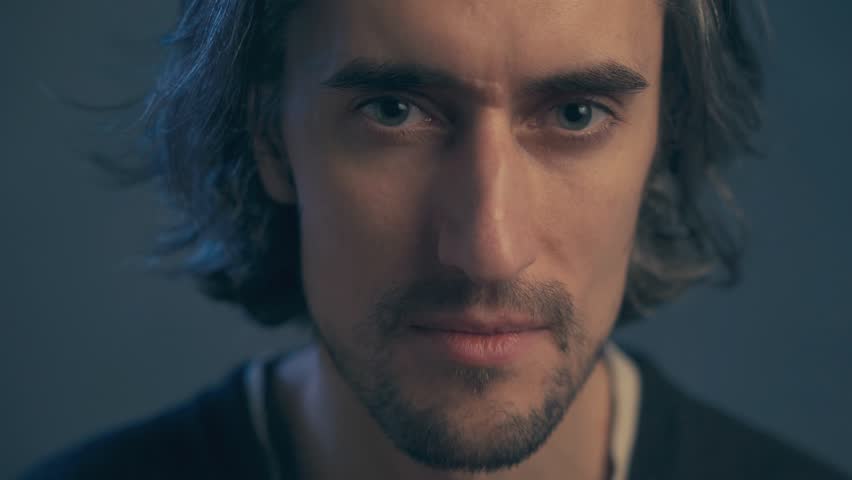 a young man with long hair, large expressive eyes, European appearance, looks intently, puzzled, slightly draws his eyebrows, licks his lips