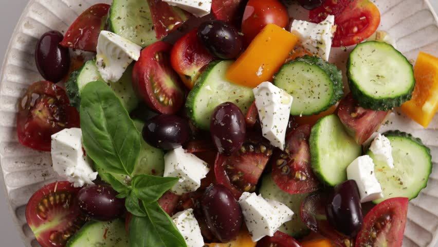 Greek salad details on plate rotation top view on light surface food
