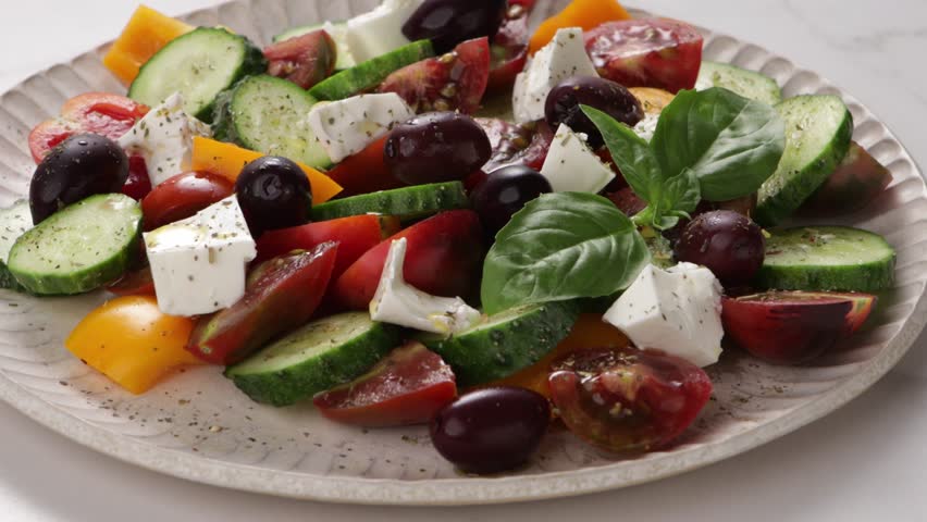 Greek salad side view on plate on light surface food