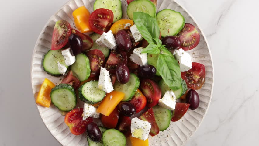 Greek salad on plate top view on light surface food