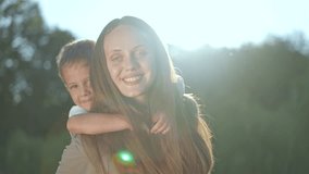Child riding piggyback on mother playing in park. Happy mother and child enjoying nature. Joyful outdoor playtime with piggyback ride. Mother bonding with child in park. Playful piggyback fun outdoors - Powered by Shutterstock - Get 15% off with code: PIKWIZARD15