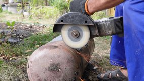 A worker cuts metal with an angle grinder. Sparks fly as the metal is cut - Powered by Shutterstock - Get 15% off with code: PIKWIZARD15