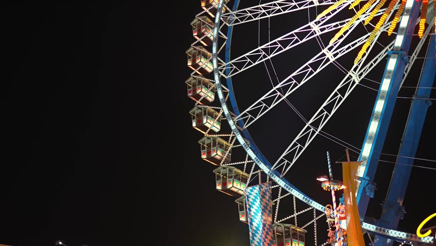 Germany, Munich. Ferris wheel with night lighting at amusement park during Oktoberfest beer festival in Munich, Bavaria, Germany. Riesenrad bei Nacht in Freizeitpark auf Oktoberfest. 