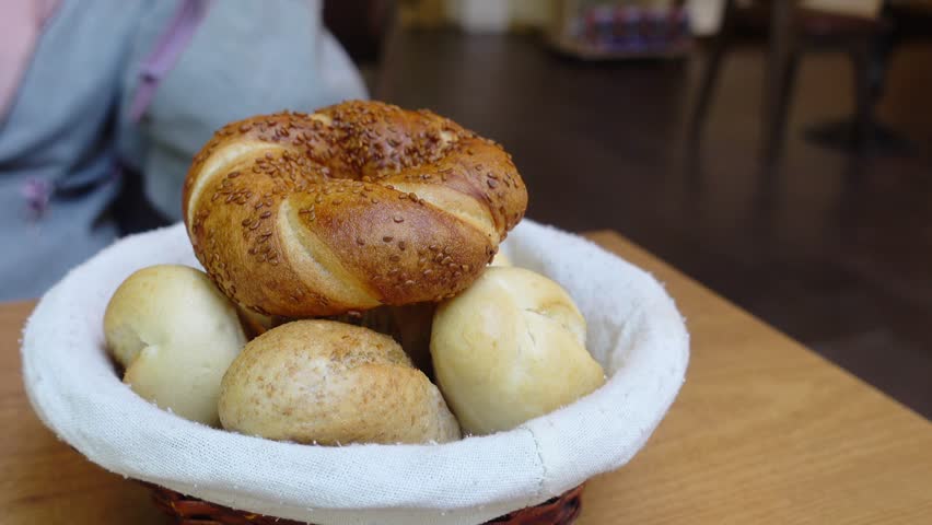 woman hand pick baked bun on table 