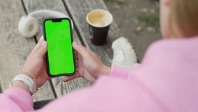 Young Woman Using Smartphone in Vertical Mode with Green Mock-up Screen Outside, Doing Swiping, Scrolling Gestures. Internet Social Networks Browsing News, Financial Reports - Powered by Shutterstock - Get 15% off with code: PIKWIZARD15