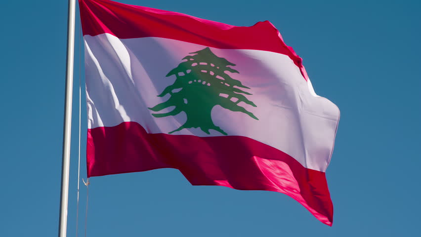 Lebanese Flag Waves the Wind. The Big State Flag is illuminated by the sun and flutters epically in the wind against the blue sky. Slow Motion