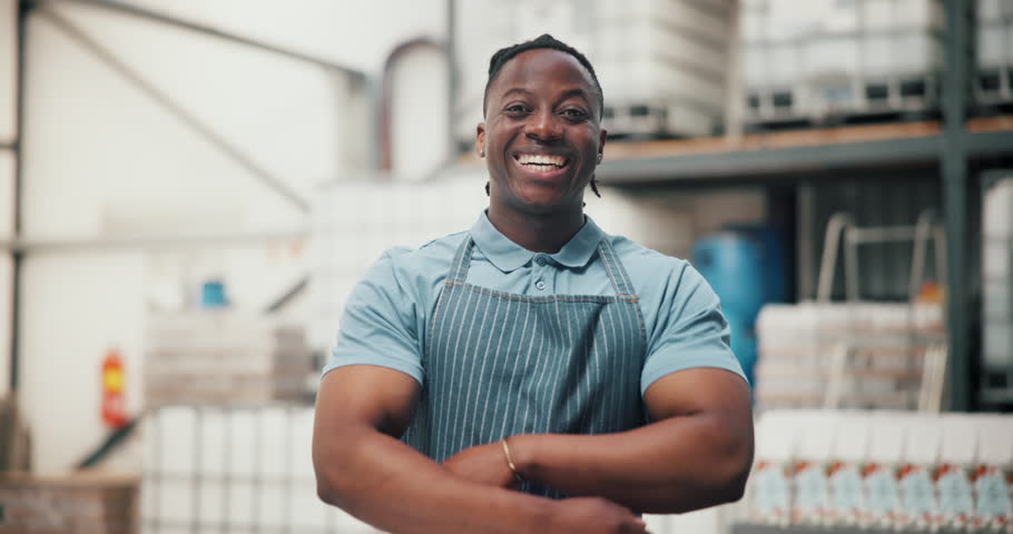 Smile, industry and distillery with arms crossed and man for distribution, manufacturing or alcohol production. Fermentation technician, quality control and brewery with person for storage process