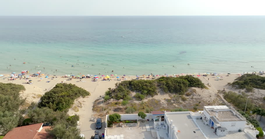 Aerial view of people on vacation. They are on a public beach in San Pietro in Bevagna in Salento, Puglia, Italy.