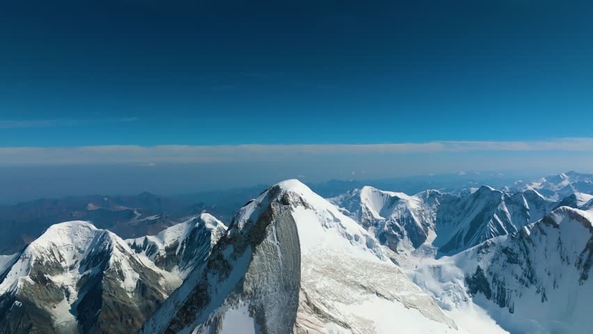 Glacier and snowy mountain drone view. Aerial shot of Khan Tengri Peak. Kyrgyzstan. Tian Shan mountains and awesome landscape. 4K