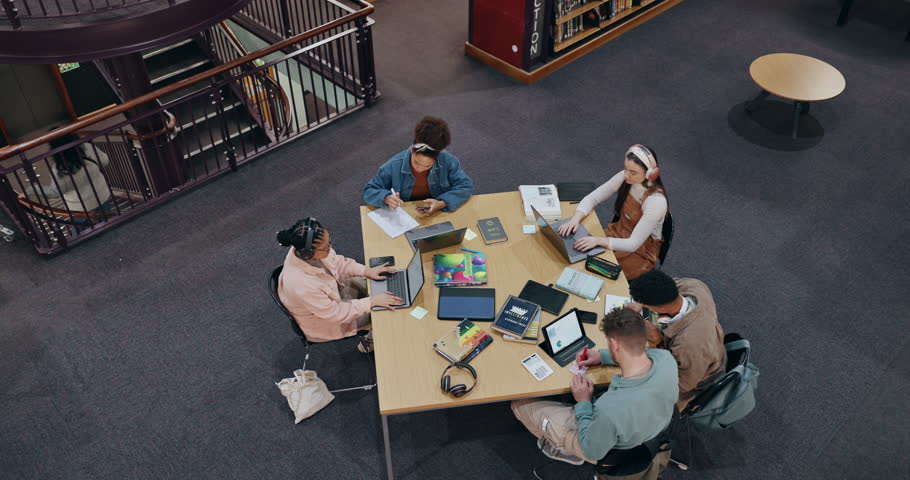 Above, people and laptop in library for education, studying and research for exam preparation. Students, group and tech at table for information, productivity and reading with notes in university