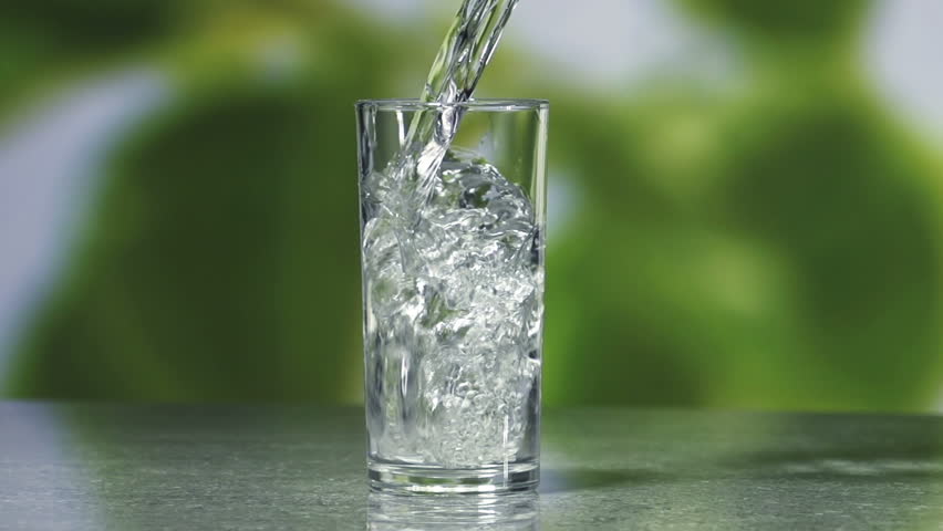 Fresh cool water pouring in a clean glass.
