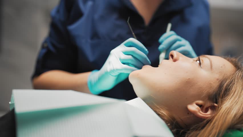 Painless dental treatment in modern clinic, woman patient lying in office. Professional stomatologist using tools for examining oral cavity, healthcare and medicine, dentistry and stomatology service