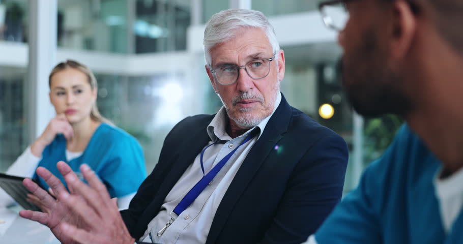 Man, medical team and meeting in hospital for healthcare, planning or workshop for investment opportunity. Mature executive leader, people or talk in boardroom for problem solving in responsibilities