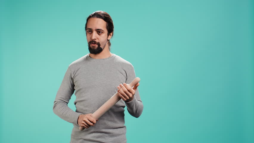 Portrait of menacing man threating to hit enemy during fight. Wrathful Arab person full of rage intimidating mate, holding weapon, isolated over studio background, camera B