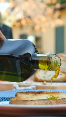 Italian Bruschetta topped with extra virgin olive oil.
Closeup of a slice of toasted bread, while oil is poured. Tuscany, Lazio, Puglia, Liguria. Italy.