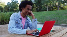 Young African American non-binary gender student person working on laptop sitting on table at college campus. Authentic person with own identity. Education and diversity concept. - Powered by Shutterstock - Get 15% off with code: PIKWIZARD15