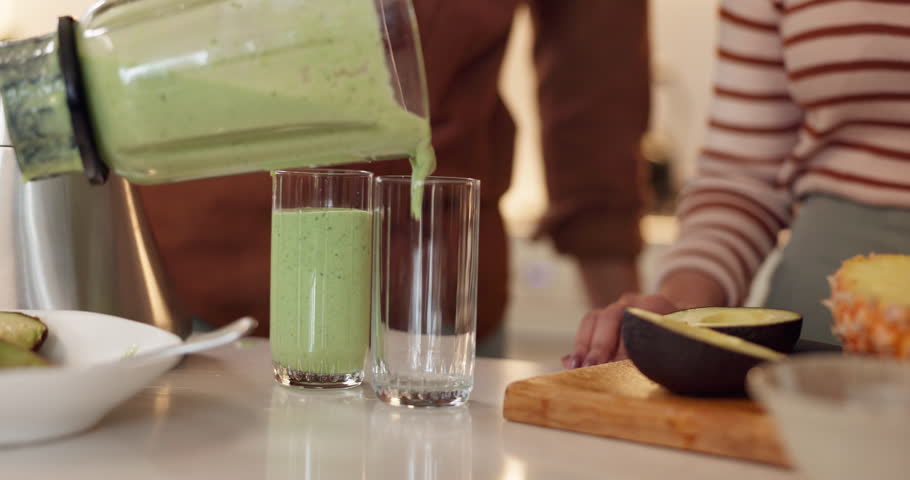 Hands, blender and couple in kitchen with smoothie, glass or fruits for gut health, diet or detox in home. People, avocado and green juice with nutrition, wellness or benefits at breakfast in morning