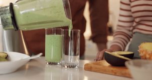 Hands, blender and couple in kitchen with smoothie, glass or fruits for gut health, diet or detox in home. People, avocado and green juice with nutrition, wellness or benefits at breakfast in morning - Powered by Shutterstock - Get 15% off with code: PIKWIZARD15
