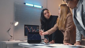 Team of business professionals is gathered around a laptop, examining financial charts and data, engaged in a collaborative discussion about market trends and investment strategies - Powered by Shutterstock - Get 15% off with code: PIKWIZARD15