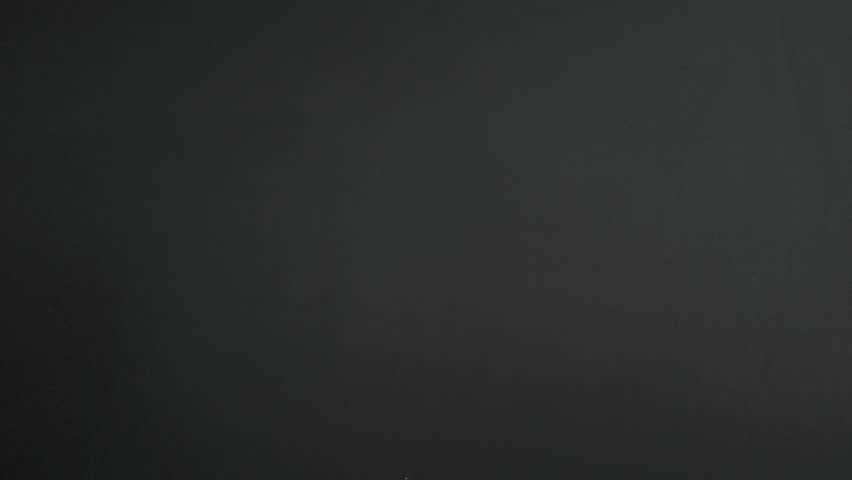 Wipe off 2024 and writing number 2025 on a blackboard using chalk in a classroom setting