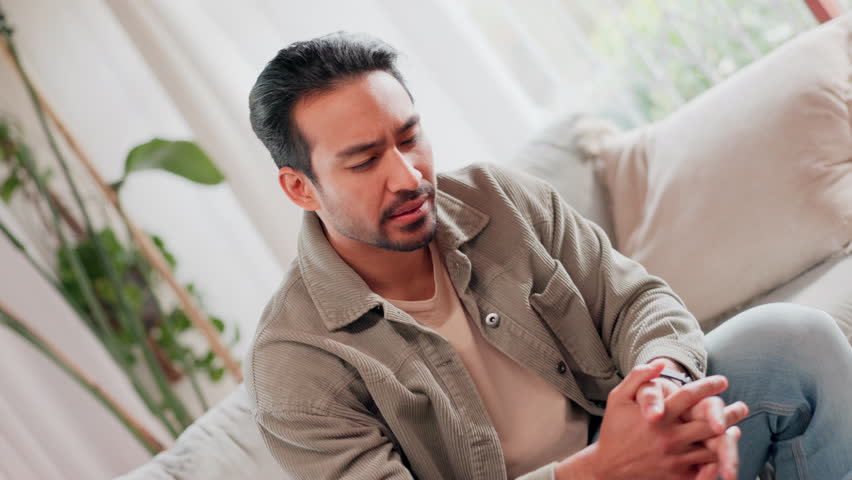 Asian man, headache and stress with vertigo on sofa for pain, dizziness or illness at home. Young, male person or inflammation with migraine or dizzy head for anxiety, fatigue or frustration at house