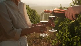 Couple in love drinking wine in vineyards during grapes harvest season. Male hand pouring red wine into glass at sunset. Travel, dating outdoors in nature, anniversary celebration - Powered by Shutterstock - Get 15% off with code: PIKWIZARD15