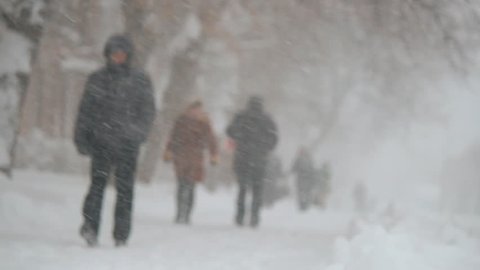 people walking on snowy road. Blizzard, snowfall. Christmas and New Year winter weather.