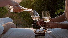 Couple in love drinking wine in vineyards during grapes harvest season. Male hand pouring white wine into glass at sunset. Travel, romantic date outdoors in nature, anniversary celebration - Powered by Shutterstock - Get 15% off with code: PIKWIZARD15