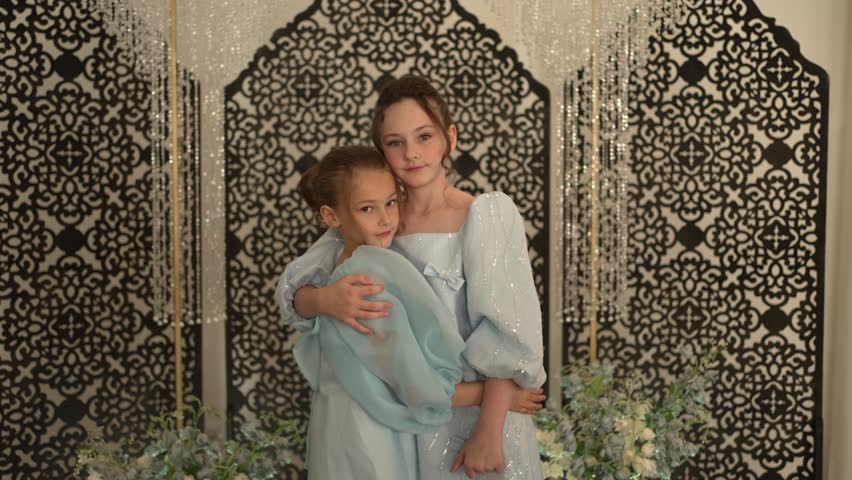 Two girls in elegant dresses are hugging. Concept of formal reception.