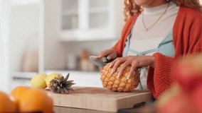 Hands, woman and cutting fruit at kitchen for healthy snack, diet meal and nutrition. Female person, home and pineapple for juice with vitamins, organic ingredients and vegan food on chopping board - Powered by Shutterstock - Get 15% off with code: PIKWIZARD15