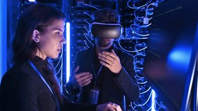 Woman programming in a server room while a man is using a Virtual Reality headset - Powered by Shutterstock - Get 15% off with code: PIKWIZARD15