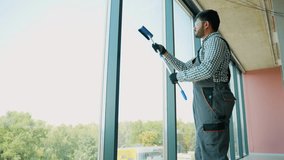 Pakistani service worker cleaning office windows, cleaning service - Powered by Shutterstock - Get 15% off with code: PIKWIZARD15