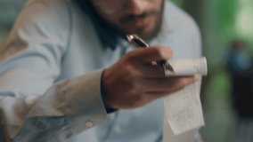 Indian Arabian male business man freelancer guy visitor count bills in cafe write notes busy multitasking businessman talk mobile phone check budget bank invoice paperwork pay finance online laptop - Powered by Shutterstock - Get 15% off with code: PIKWIZARD15