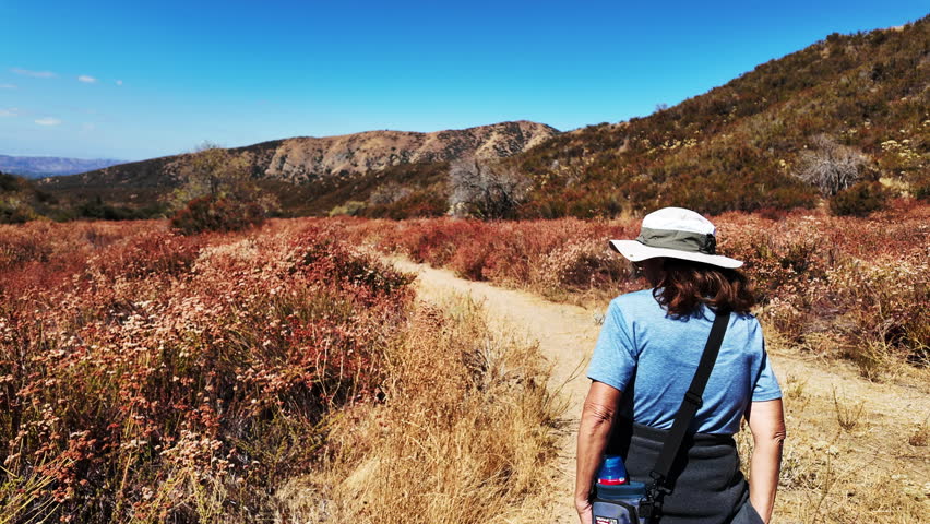 Hiking a Trail in a Chaparral Hilly Habitat looking at a Woman Exploring the area while hiking