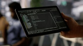 Data scientist uses tablet to check on machine learning models that can analyze data to automate decision making processes. Close up of IT specialist using device to do programming in office, camera A - Powered by Shutterstock - Get 15% off with code: PIKWIZARD15