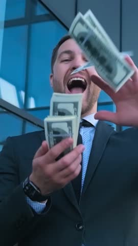 Insanely happy rich young businessman scatters money. Vertical video. A rich man