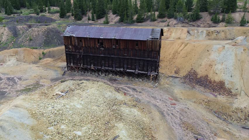 Mining ruins near Leadville, Colorado. Close up flyover shot of an extensive, large mining site with a number of buildings and a large deposit of tailings.