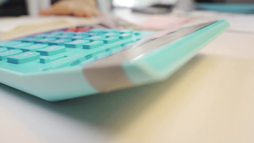 Person Using a Calculator to Perform Economic and Budget Calculations, Focusing on Household Financial Management, Carefully Balancing Income and Expenses for Personal Economic Stability